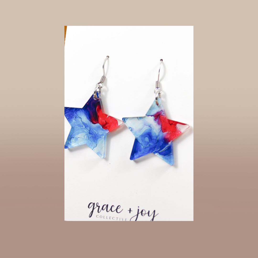 4th of July star dangle earrings in red, white and blue marbled acrylic with silver-tone hooks.