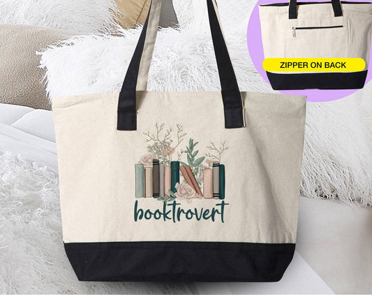 Canvas zipper tote with natural cotton body, black base and handles, and a botanical book graphic above “booktrovert”; Booktrovert - Book Reading Introvert.