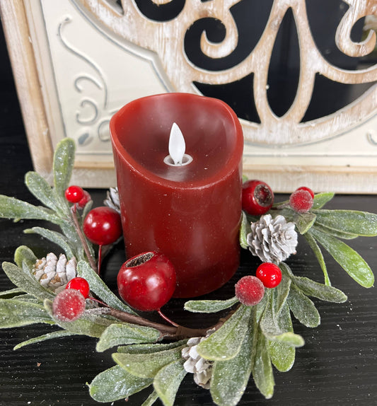 Mistletoe 4.5in Candle Ring with frosted green leaves, red berries, and white pinecones surrounding a red candle.