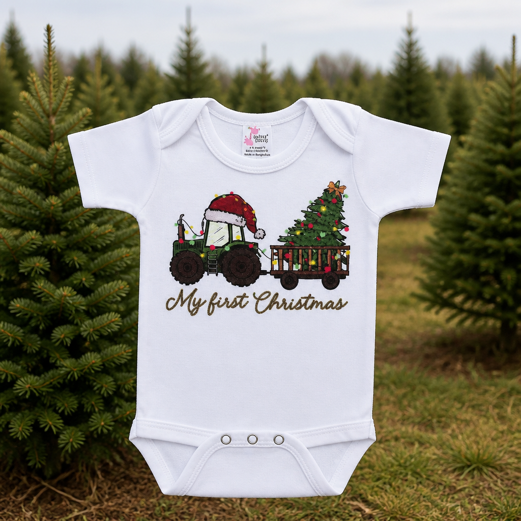 Baby bodysuit in white cotton with a colorful Christmas tractor and tree design, featuring the words My First Christmas.