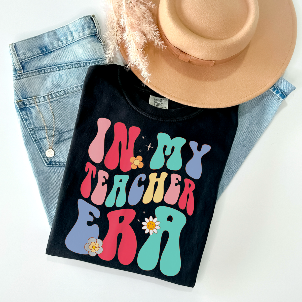 Black cotton-blend sweatshirt with colorful groovy lettering, daisy accents, and the phrase “In My Teacher Era”
