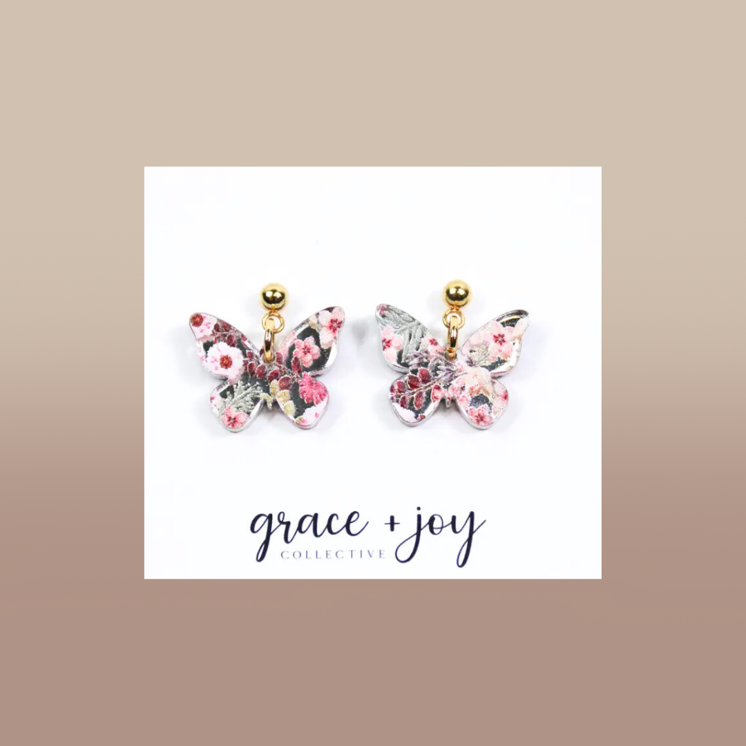 Pink Floral Butterfly dangle earrings in clear acrylic, with pink floral patterning, butterfly shapes, and gold-tone studs.